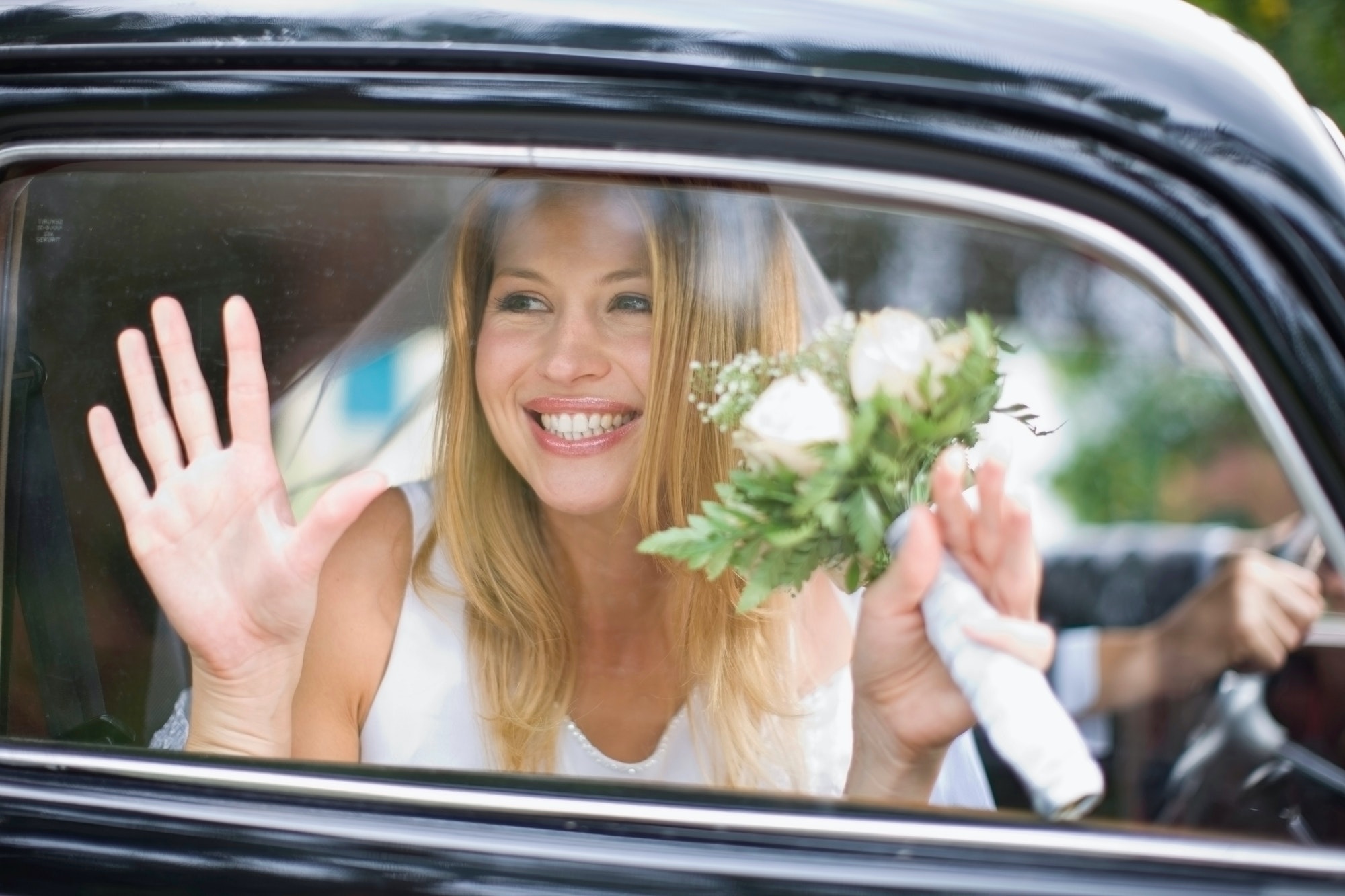 Bruid in auto onderweg naar haar buitenlandse bruiloft